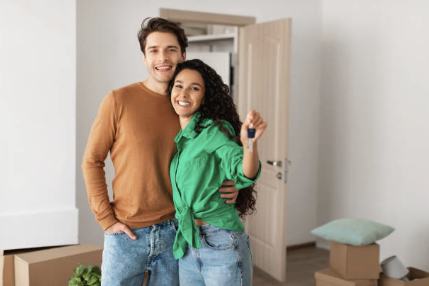 A happy couple holding the keys among moving boxes